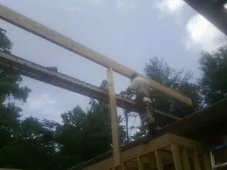 Carpenter setting a ridge beam over a new addition frame — Ice Dam Removal by Roofing Brothers in Sadsburyville