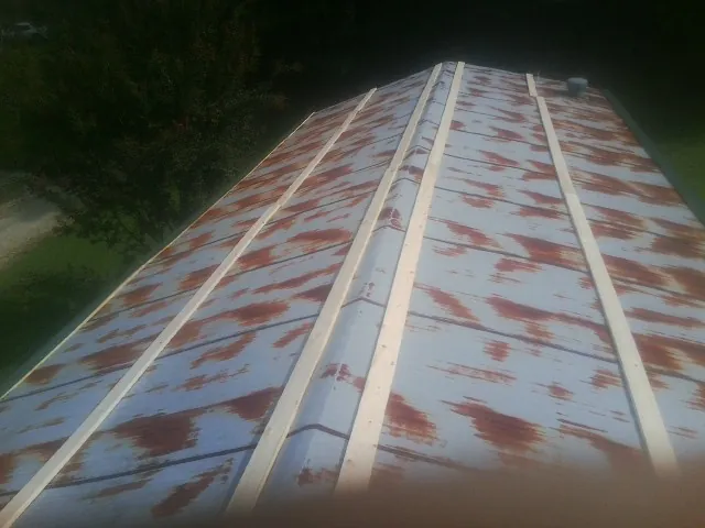Rusted metal roof panels with new wood purlins before replacement — Storm Damage Roof Repair in Sadsburyville by Roofing Brothers
