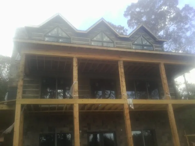 Dormers and porch framing on a large log home under construction — Roof Coating work by our crew in Sadsburyville